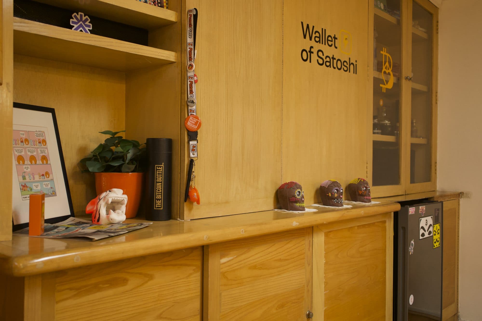 The kitchen counter: wood cabinets, a mini fridge, and a row of painted skulls