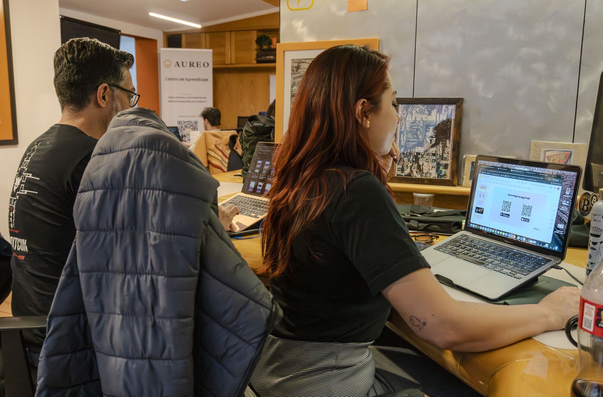 Miembros trabajando en sus laptops en la mesa larga